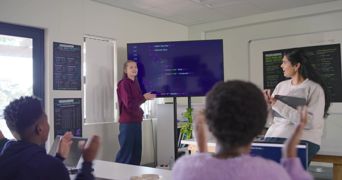 Teen female presenting in hoodie pointing at screen explaining code as teacher speaking, copy space