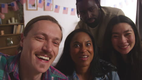 POV-Shot-Of-Friends-At-Home-Celebrating-With-Party-For-American-Independence-Day-4th-July-Making-Video-Call-On-Mobile-Phone