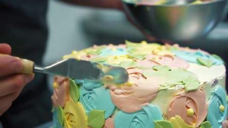 a beautifully decorated cake with colorful floral designs showcasing the art of cake decorating and icing techniques in a professional kitchen setting
