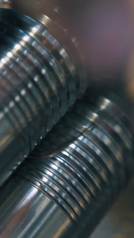 cu: skilled craftsman forge-rolls thin gold metal wire with machine roller at workplace in jewelry workshop close view