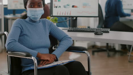 Black-project-manager-with-disabilities-wearing-face-mask-looking-at-camera