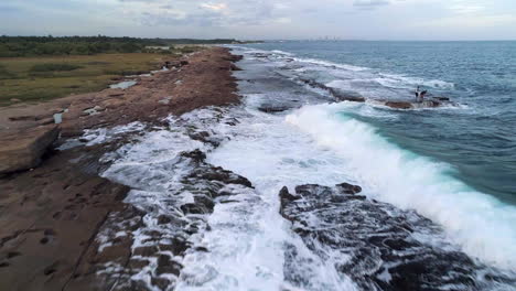 stunning aerial footage where some children fish on the strong waves of the sea