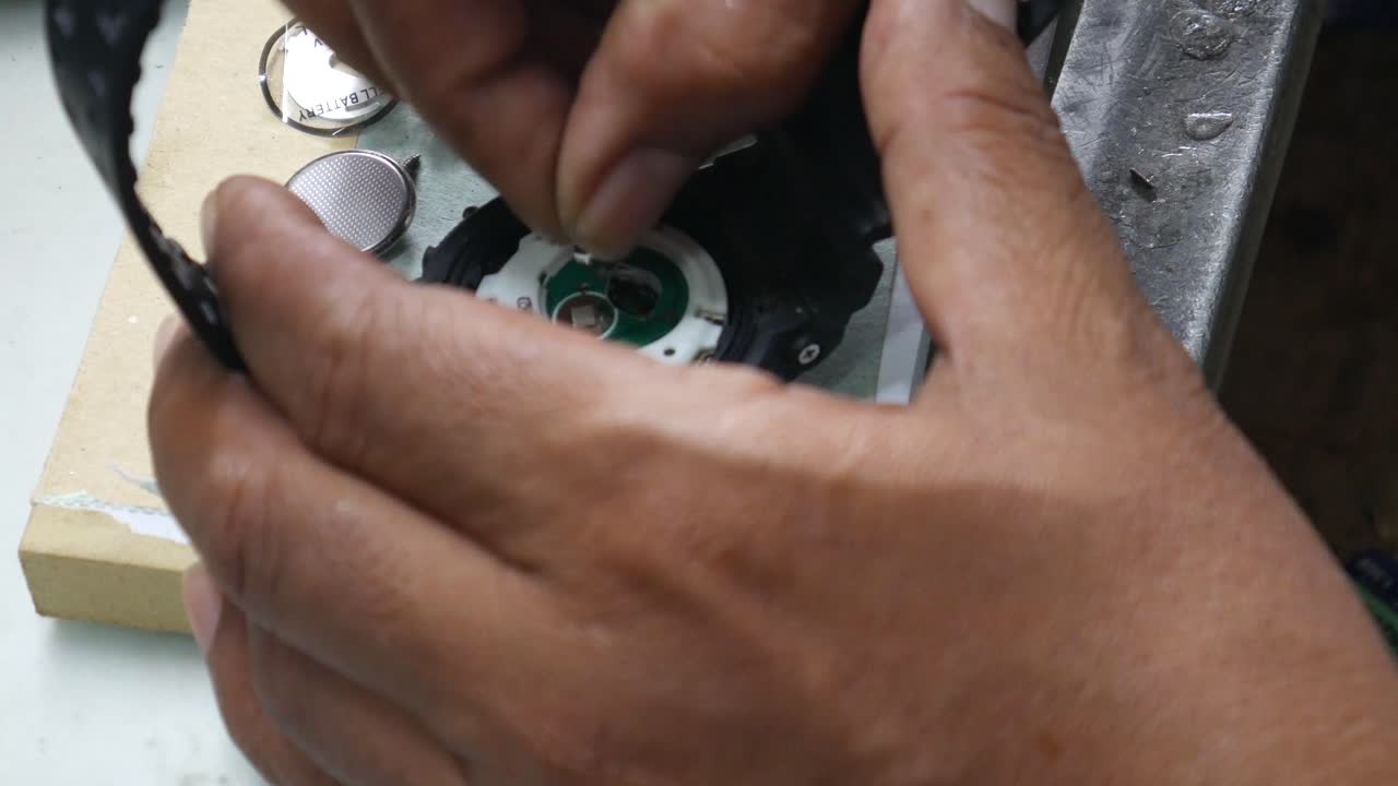 Watch repairman installing a tiny battery