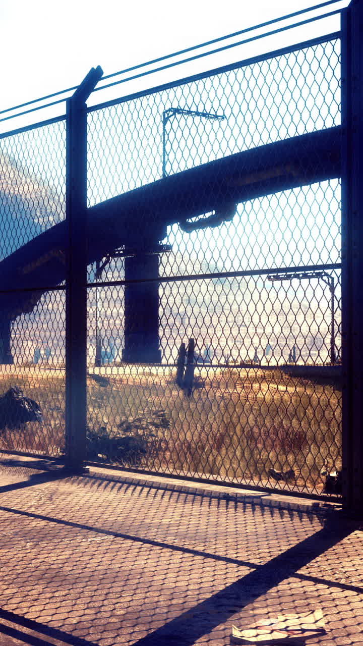 Urban landscape with a fence and a solitary object under the sun