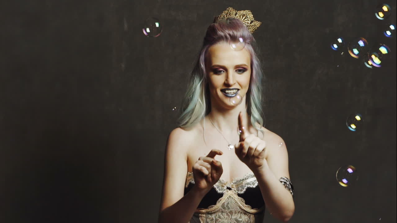 Woman blowing soap bubbles. Young beautiful girl blowing bubbles in a studio