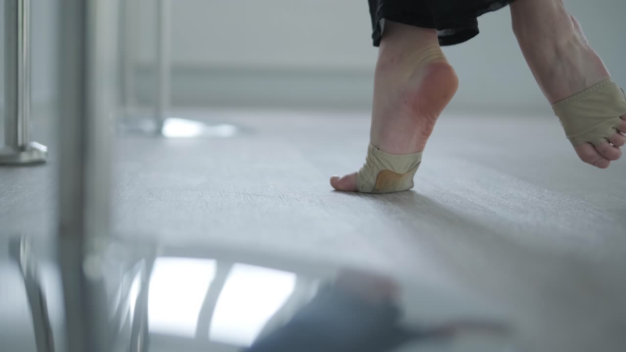 chica en forma con ropa negra actuando contemporáneamente. bailarina muestra movimientos fluidos, cuerpo y manos ondas en la habitación blanca. coreografía de danza de ballet moderno. joven se mueve suavemente
