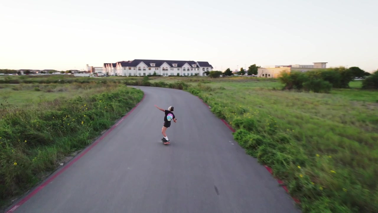 athlete rides a onewheel down an empty road