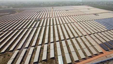 extensive solar panel arrays at dust prone african project site showcasing the challenges of solar farms at sunset - aerial sliding overview