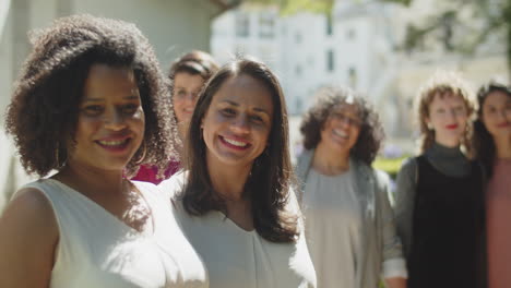 pareja de lesbianas posando para la cámara con sus amigos, besándose y saludando con la mano durante la ceremonia de la boda