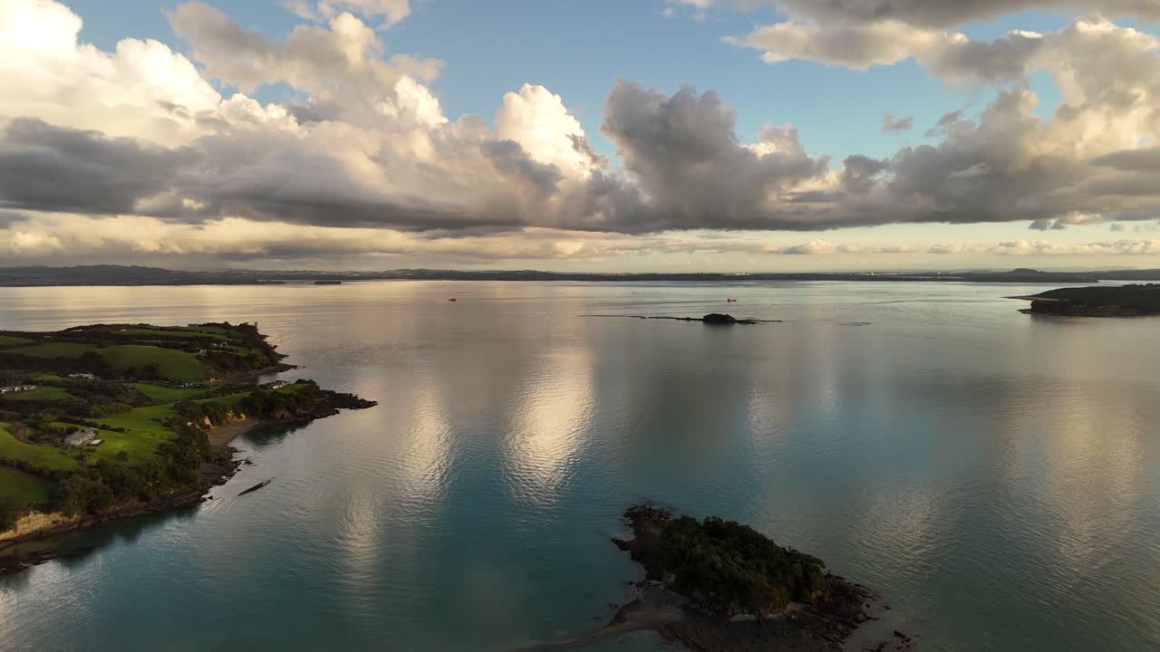 Peaceful bay lagoon with cliffs coastline at sunset time. Aerial wide shot. Panorama view. Waiheke island, New Zealand at dusk.
