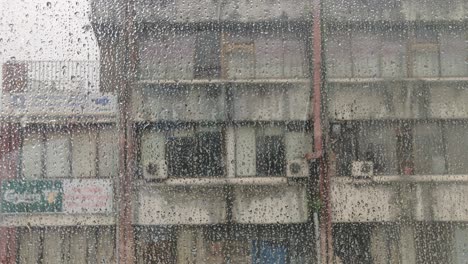 gotas de lluvia deslizándose hacia abajo sobre una ventana durante el monzón