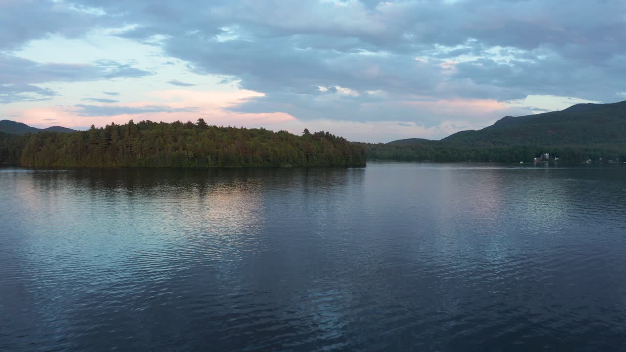 Drone following the rippled water on a lake at dusk in the Eastern Township, Quebec, Canada