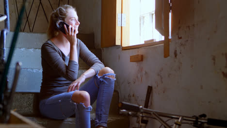 woman talking on mobile phone at workshop 4k