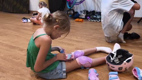 children learning roller skating and putting on protective gear