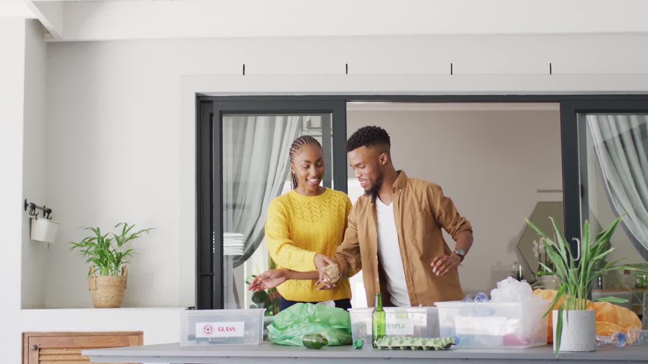 feliz pareja afroamericana reciclando desechos