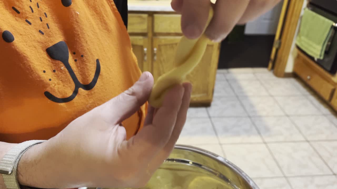 las manos del hombre manejando la masa en forma de galleta, de cerca