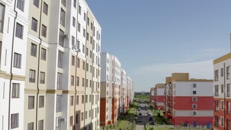 from above drone view flying over street with new colorful residential buildings in modern urban district in sunny summer day