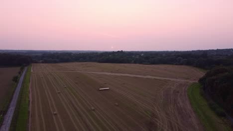 Drone-Disparó-Panoramización-De-Un-Gran-Campo-De-Granja-De-Heno-Al-Atardecer