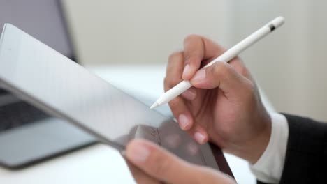 businessman using stylus pen signing contract on digital tablet at work in office indoors. close up hand write business agreement of contract. electronic signature on tablet computer.