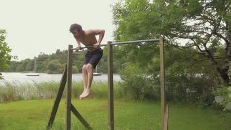 Fit man doing muscle-up bodyweight exercise on home gym Slow-Motion