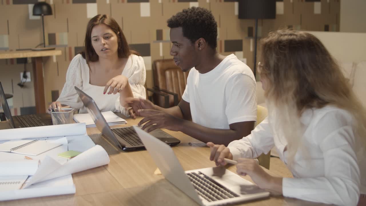Startup team working at laptops in co-working space