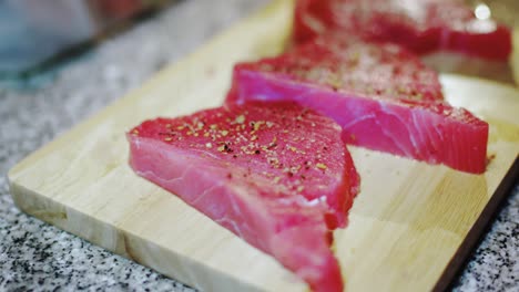 cooking tuna steak with spices on wooden board for a high protein dinner at home