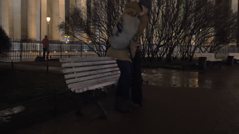 Man-sitting-down-on-the-bench-in-park-during-evening-walk