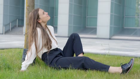 Beautiful-woman-with-formal-clothes-resting-near-tree-in-urban-area