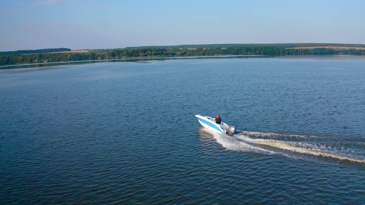 Motor boat travels along river. Aerial view of high speed motor boat floating on river