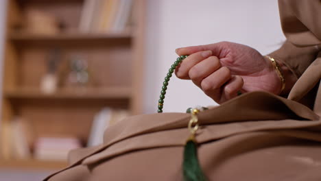 Close-Up-Of-Muslim-Woman-With-Prayer-Beads-At-Home-Praying