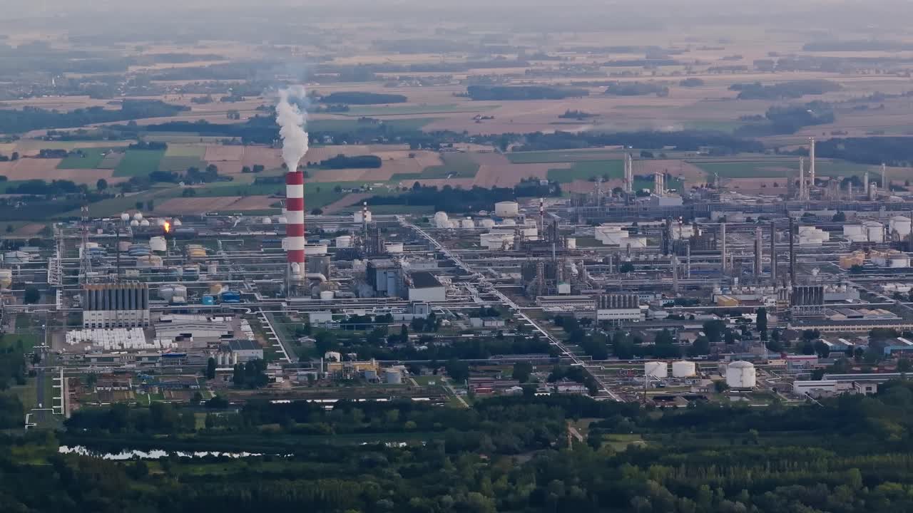 Industrial refinery plant with chimneys and tanks in Polish landscape, Płock