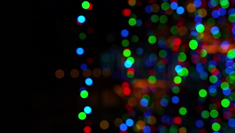 4k imágenes de año nuevo/navidad desenfocadas luces intermitentes borrosas guirnalda en la oscuridad. vacaciones de invierno recursos artísticos video concepto.