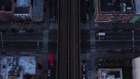 un dron épico asciende perpendicularmente a lo largo de las vías del tren en harlem justo después del amanecer, una gran revelación del centro de manhattan, nueva york