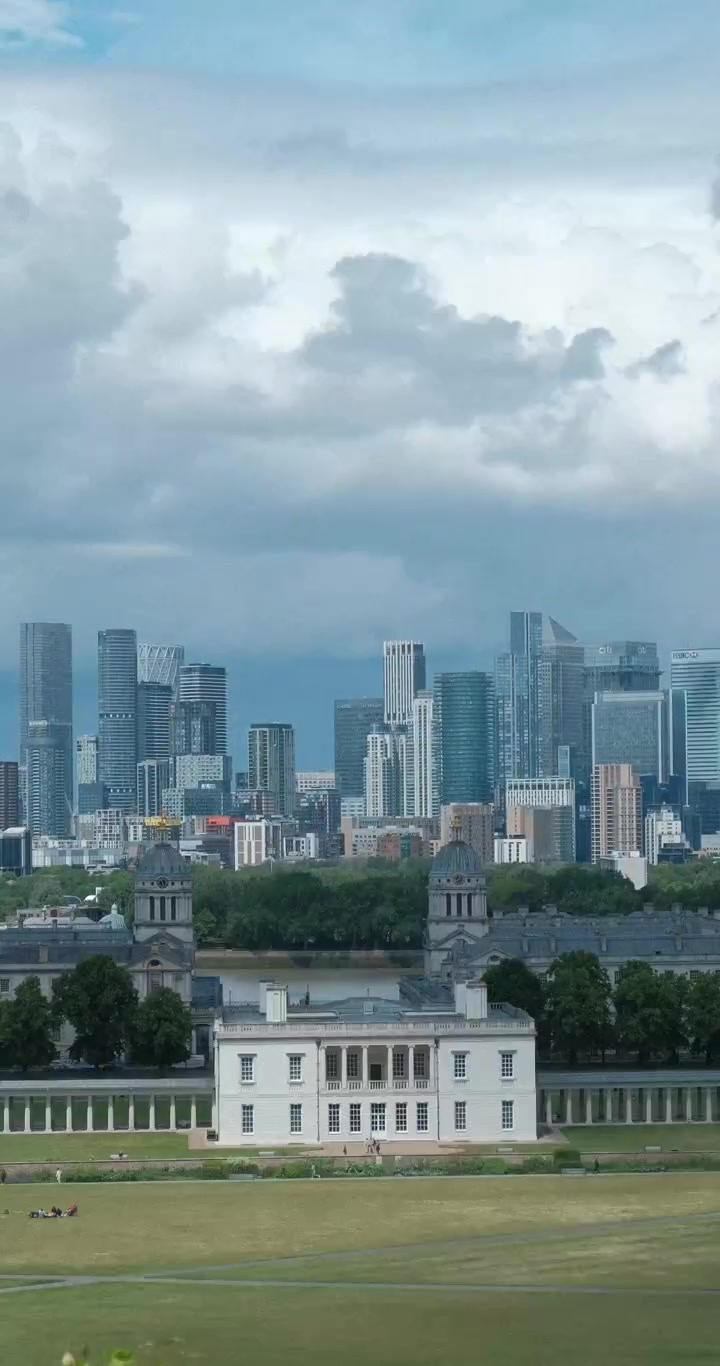 Timelapse vertical do Greenwich Park mostrando o Old Royal Naval College, o horizonte de Canary Wharf e nuvens flutuando sobre a paisagem