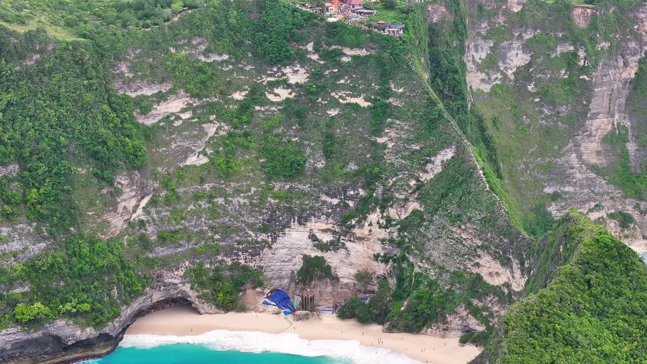 Construction project at Kelingking Beach, Nusa Penida, Bali. Crane on top of the cliff. Aerial.