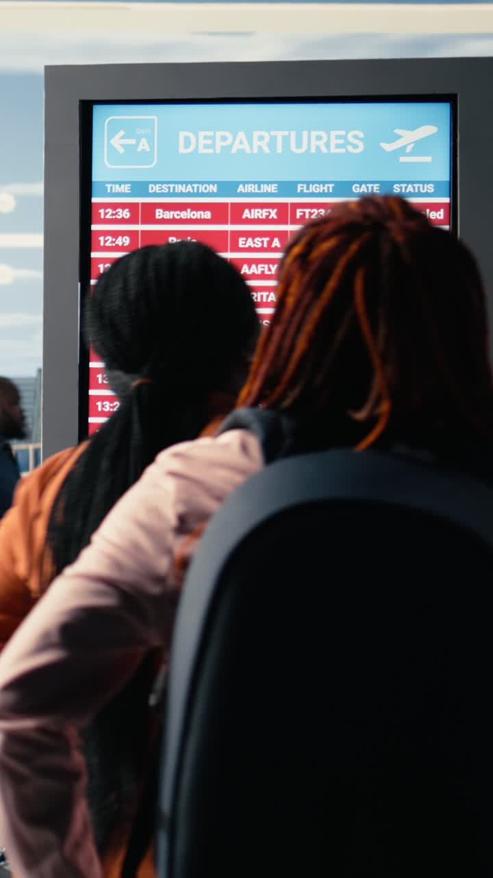Video vertical: Terminal de aeropuerto, vuelos cancelados, personas angustiadas leyendo advertencias rojas