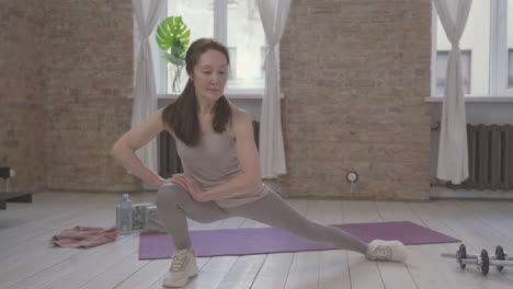 old female doing exercises at home