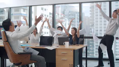 hombre de negocios y mujer de negocios lanzando documentos sintiéndose felices de los logros después del resultado exitoso en la sala de reuniones en una pequeña oficina moderna en la ciudad urbana.