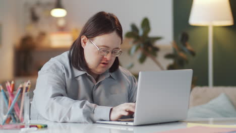 man with down syndrome using laptop at home