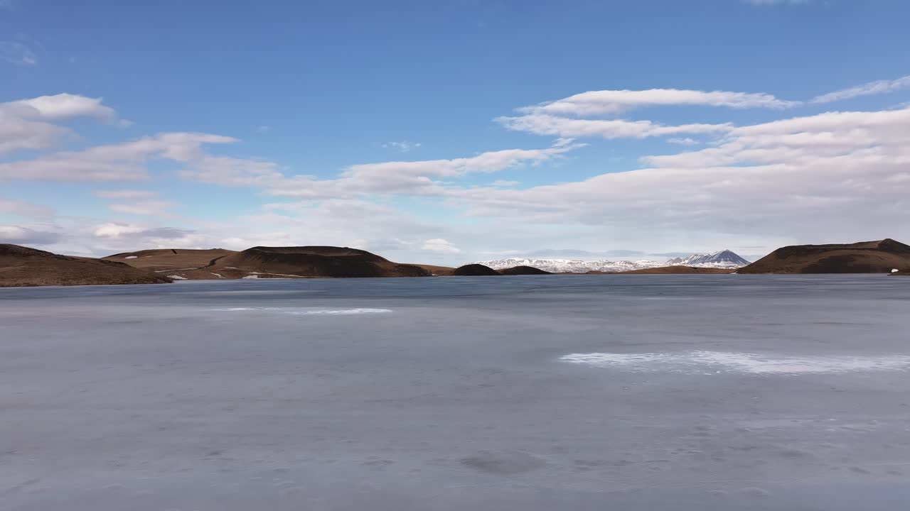 Frozen lake near Reykjahlíð with Mývatn views and snowy peaks in Skútustaðir, Iceland
