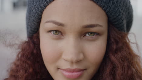 close up portrait beautiful young mixed race woman turns head smiling happy independent female looking calm wearing beanie hat wind blowing hair slow motion