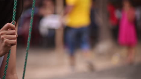 cerca de una niña en un columpio de madera y cuerda