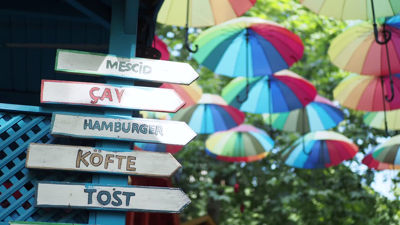 방향 표지판 과 우산 을 가진 다채로운 거리 음식 레스토랑