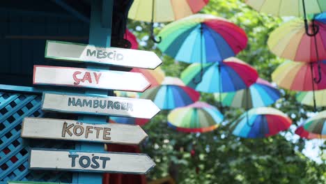 colorful street food restaurant with directional signs and umbrellas