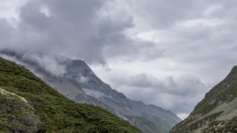 time lapse footage of grey swirling clouds gathering around a high alpine mountain peak in eastern alps of switzerland