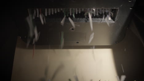 shredder cutting paper from below, empty basket, hard light
