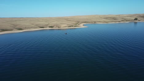 blue lake with boats among canadian prairies