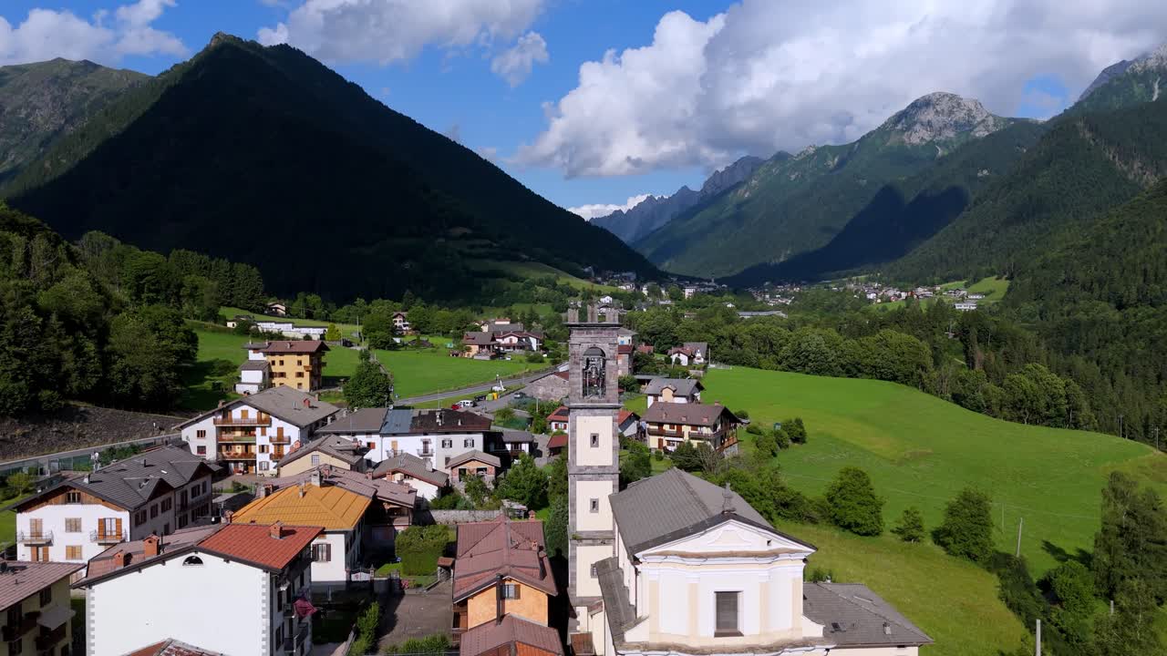 Cinematic aerial view of a traditional mountain church in Val di Scalve, Orobie Alps. Scenic Italian village religious architecture and landscape