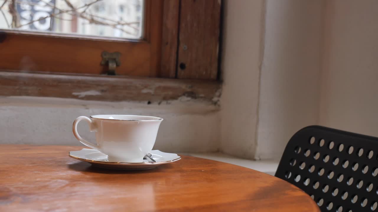 Una taza de café junto a la ventana.