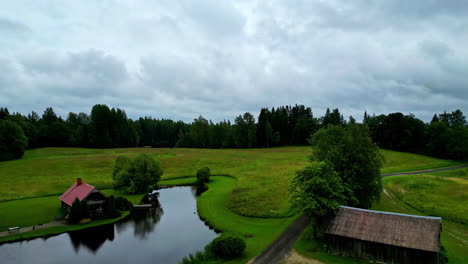 Countryside-home-estate-near-water-pond,-aerial-ascend-reveal-shot